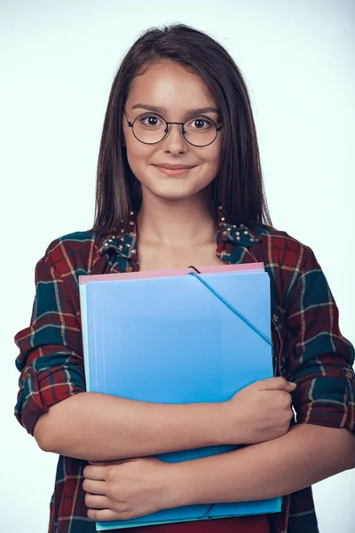 Teenager-Schülerin mit Brille hält Bücher in der Hand. — Stockfoto