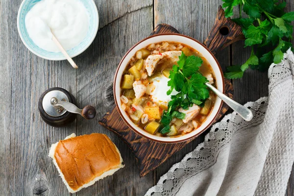 Zuppa tradizionale russa-Rassolnik con cetriolo sottaceto, orzo, pollo, pomodori e prezzemolo in ciotola di ceramica . — Foto Stock