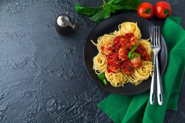 Spagetti makarna köfte, domates sosu ve fesleğen koyu arka plan üzerinde.