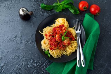 Spagetti makarna köfte, domates sosu ve fesleğen koyu arka plan üzerinde.