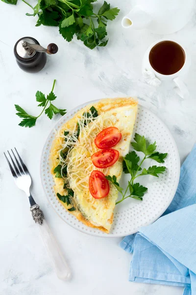 Omelette aux épinards, persil et fromage pour le petit déjeuner sur un fond clair . — Photo