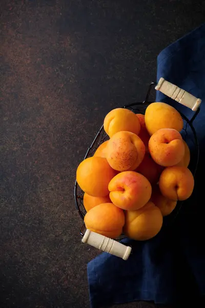 Karanlık bir arka plan üzerinde lezzetli olgun kayısı. Seçici odak. Üstten Görünüm.