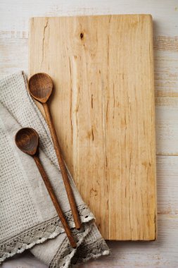ahşap stand, basit eski kaşık ve hafif bir arka plan üzerinde kumaş peçete. Mutfak aksesuarları konsepti.