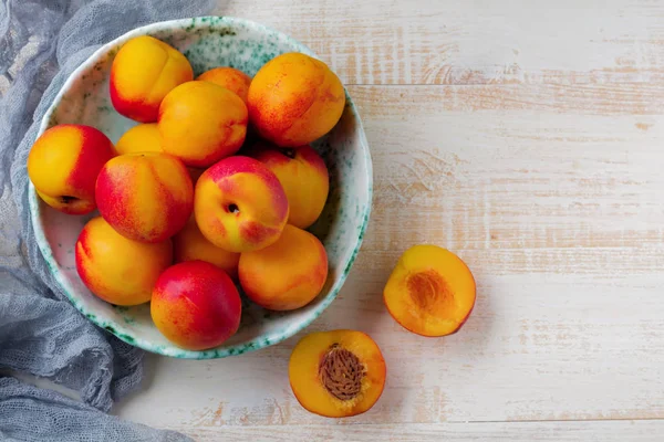 Nectarinas de frutas jugosas frescas en rejilla metálica sobre fondo de madera blanca . — Foto de Stock