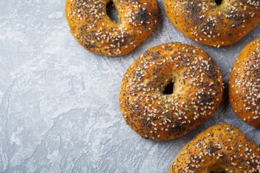 Haşhaş tohumu, susam hafif beton veya taş arka plan ile çeşitli taze tahıllı simit.