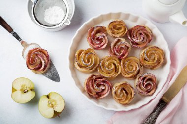 Bir elma ile lezzetli börek seramik formunda hafif bir beton veya taş arka plan üzerinde yükseldi.. 