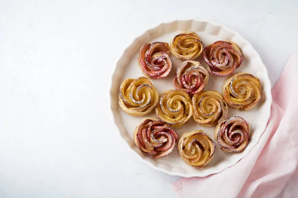 Delicious pies with an apple rose in ceramic form on a light concrete or stone background. — Stock Photo, Image
