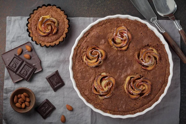 Pastel de chocolate casero con frangipane y flores de manzana sobre un fondo de hormigón oscuro o piedra — Foto de Stock