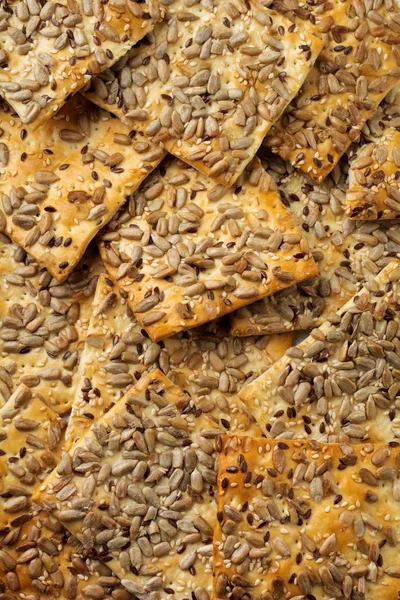 Abstract background of useful bread with sunflower seeds, flax and sesame seeds. — Stock Photo, Image