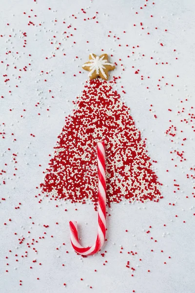 Dulces de árbol de Navidad, pan de jengibre, malvaviscos y polvo multicolor de confitería sobre fondo de piedra clara . — Foto de Stock