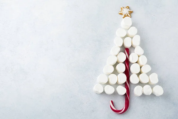 Christmas tree candy, gingerbread, marshmallows and confectioner's multicolored powder on  light stone  background. — Stock Photo, Image