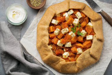 Galette'ye veya bir eski beton veya taş gri arka plan üzerinde kabak ve beyaz peynirli pizza. 