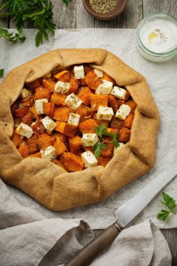 Galette'ye veya bir eski beton veya taş gri arka plan üzerinde kabak ve beyaz peynirli pizza. 