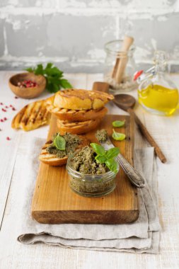 Ezme, siyah ve yeşil zeytin, fesleğen ve eski ahşap masa arka plan üzerinde ekmek ile geleneksel Provence çanak.