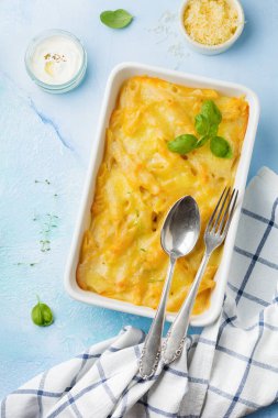 Mac ve peynir. Makarna, peynir ve hafif beton veya taş zemin üzerine seramik formundaki Beşamel sos güveç.