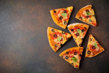 Pizza margarita domates, mazarella ve karanlık bir beton veya taş zemin üzerine zeytin dilimleri ile. 