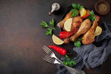 Kızarmış tavuk sivri shanks bir dökme demir tavada bir karanlık beton veya taş arka plan.