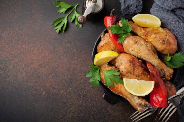 Kızarmış tavuk sivri shanks bir dökme demir tavada bir karanlık beton veya taş arka plan.