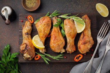 Kızarmış tavuk sivri shanks bir dökme demir tavada bir karanlık beton veya taş arka plan.