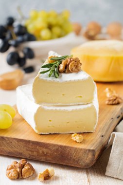 Camembert peyniri üzüm, ceviz ve fesleğen gri hafif beton veya taş zemin üzerine yığını.