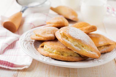 Pasties süzme peynir ve hafif bir ahşap zemin üzerine pudra şekeri ile. Geleneksel Rus pasta Sochnik.