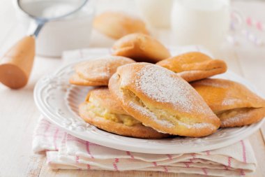 Pasties süzme peynir ve hafif bir ahşap zemin üzerine pudra şekeri ile. Geleneksel Rus pasta Sochnik.
