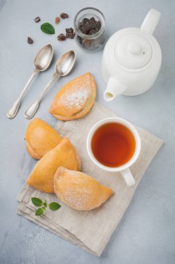 Pasties süzme peynir ve hafif bir ahşap zemin üzerine pudra şekeri ile. Geleneksel Rus pasta Sochnik.