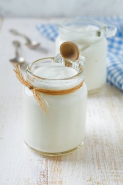 Taze doğal yoğurt hafif ahşap zemin üzerine cam kavanozda.