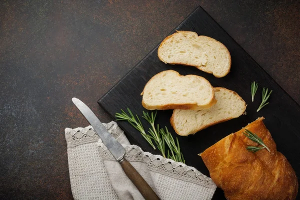 Italian traditional Ciabatta bread with olives, olive oil, pepper and rosemary on a dark stone or concrete background. — Stock Photo, Image