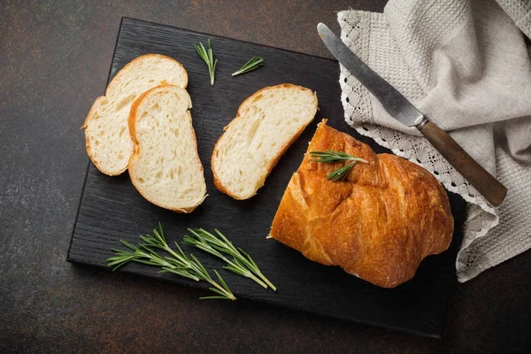 Italian traditional Ciabatta bread with olives, olive oil, pepper and rosemary on a dark stone or concrete background. — Stock Photo, Image