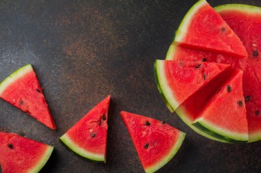 Taze çiğ karpuz parçalar halinde gri taş zemin üzerine kesilmiş..