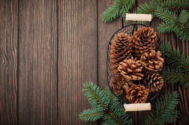 Noel ve yeni yıl arka plan. Köknar-ağaç dalları, Noel ağacı oyuncaklar, yıldız, kar tanesi ve koniler koyu kahverengi ahşap zemin üzerinde. Seçici odak. Üstten Görünüm. Kopya alanı.