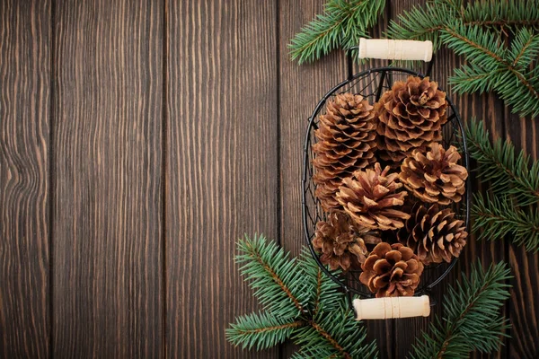 圣诞节或新年背景 冷杉树分支 圣诞树玩具 雪花和锥体在深棕色木背景 选择性焦点 顶部视图 复制空间 — 图库照片