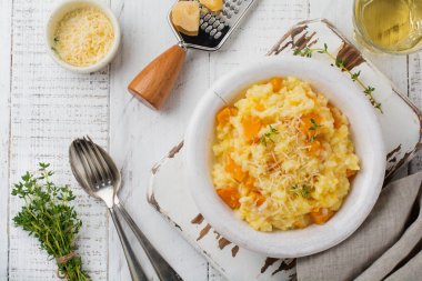 Kabak risotto ile kekik, sarımsak, parmesan peyniri ve hafif ahşap zemin üzerine beyaz şarap. Seçici odak. Rustik tarzı. Üstten Görünüm.