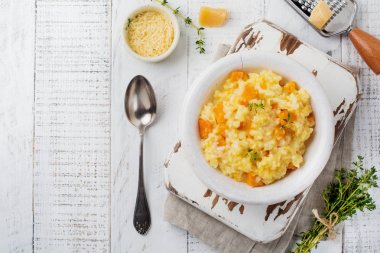 Kabak risotto ile kekik, sarımsak, parmesan peyniri ve hafif ahşap zemin üzerine beyaz şarap. Seçici odak. Rustik tarzı. Üstten Görünüm.