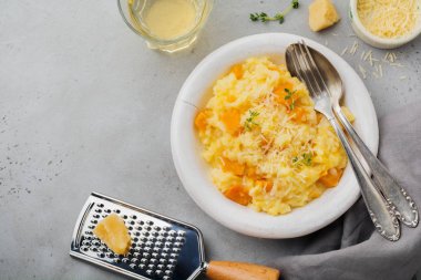Kekikli balkabaklı risotto, sarımsak, parmesan peyniri ve gri beton ya da taş zemin üzerinde beyaz şarap. Seçici odaklanma. Kırsal tarzda. Üst görünüm.