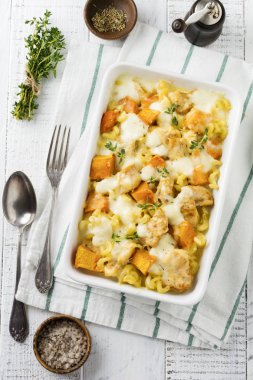 Tavuk eti, kabak, makarna, kekik, peynir ve hafif beton veya taş zemin üzerine seramik formundaki Beşamel sos güveç. Seçici odak. Üstten Görünüm. Kopya alanı.