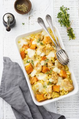 Tavuk eti, kabak, makarna, kekik, peynir ve hafif beton veya taş zemin üzerine seramik formundaki Beşamel sos güveç. Seçici odak. Üstten Görünüm. Kopya alanı.