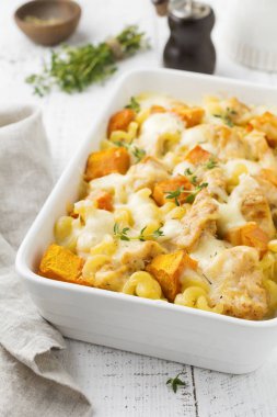 Tavuk eti, kabak, makarna, kekik, peynir ve hafif beton veya taş zemin üzerine seramik formundaki Beşamel sos güveç. Seçici odak. Üstten Görünüm. Kopya alanı.