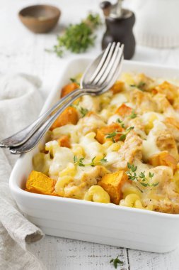 Tavuk eti, kabak, makarna, kekik, peynir ve hafif beton veya taş zemin üzerine seramik formundaki Beşamel sos güveç. Seçici odak. Üstten Görünüm. Kopya alanı.