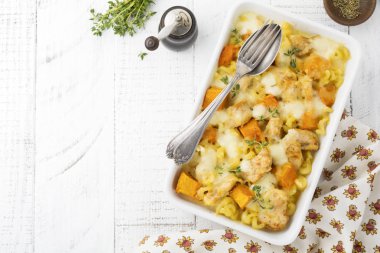 Tavuk eti, kabak, makarna, kekik, peynir ve hafif beton veya taş zemin üzerine seramik formundaki Beşamel sos güveç. Seçici odak. Üstten Görünüm. Kopya alanı.