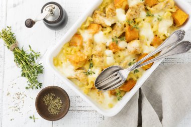 Tavuk eti, kabak, makarna, kekik, peynir ve hafif beton veya taş zemin üzerine seramik formundaki Beşamel sos güveç. Seçici odak. Üstten Görünüm. Kopya alanı.