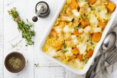 Tavuk eti, kabak, makarna, kekik, peynir ve hafif beton veya taş zemin üzerine seramik formundaki Beşamel sos güveç. Seçici odak. Üstten Görünüm. Kopya alanı.