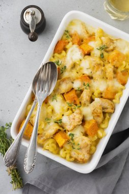 Tavuk eti, kabak, makarna, kekik, peynir ve hafif beton veya taş zemin üzerine seramik formundaki Beşamel sos güveç. Seçici odak. Üstten Görünüm. Kopya alanı.