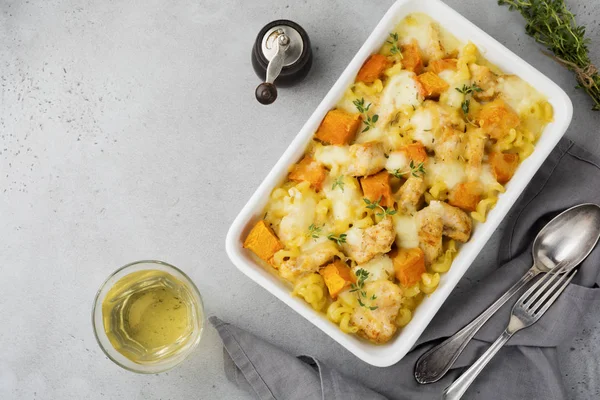 Tavuk eti, kabak, makarna, kekik, peynir ve hafif beton veya taş zemin üzerine seramik formundaki Beşamel sos güveç. Seçici odak. Üstten Görünüm. Kopya alanı.