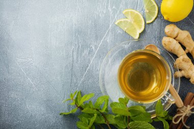 Nane, limon ve beton mavi zemin üzerine saydam bir fincan şeker ile yararlı zencefil çayı. Seçici odak. Üstten Görünüm.