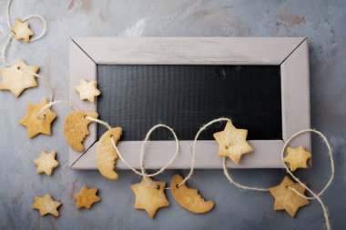 Ev yapımı kurabiye yıldız şekli şeker pudra şekeri ve mavi doku yüzey üzerinde iş parçacığında uyum ağacının dalını ile. Selektive odak. Noel ve yeni yıl arka plan. Üstten Görünüm alanı ile.