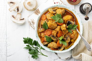 Gulaş geleneksel Macar yemeği. Biber ve domates sosu bir vintage seramik plaka ile güveç. Seçici odak. Üstten Görünüm.