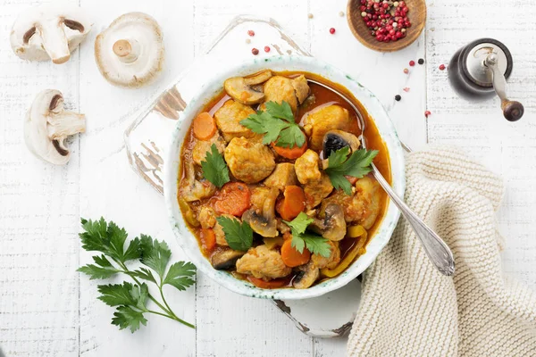 Gulaş geleneksel Macar yemeği. Biber ve domates sosu bir vintage seramik plaka ile güveç. Seçici odak. Üstten Görünüm.