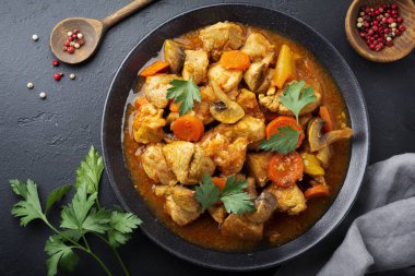 Gulaş geleneksel Macar yemeği. Koyu siyah taş veya beton arka plan üzerinde seramik tabak içinde biber ve domates soslu güveç. Seçici odak. Üstten Görünüm.